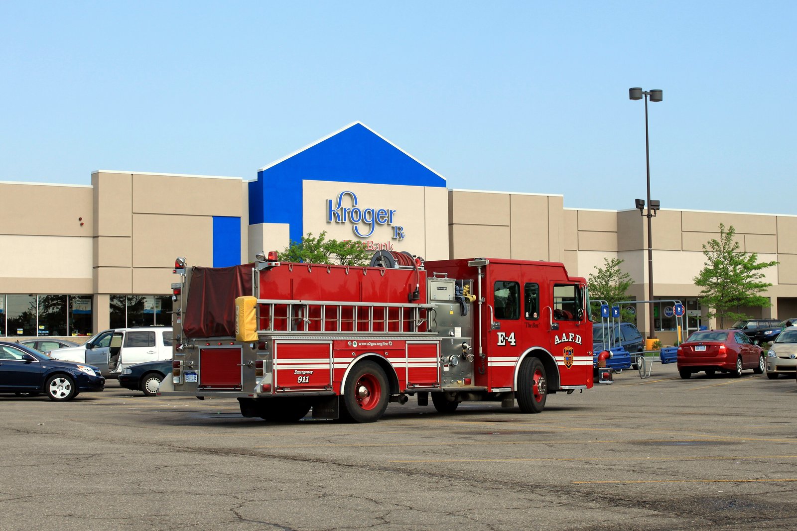 A red Ann Arbor Fire Department pumper marked E-4 parked in a store parking lot under a clear blue sky.