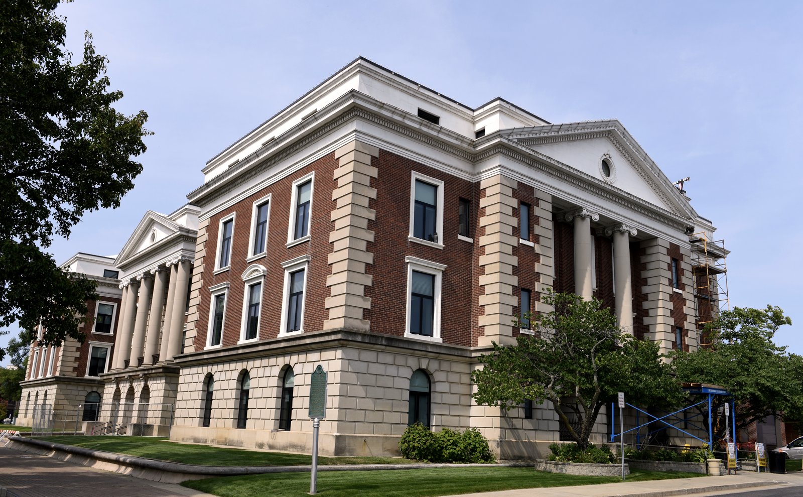 Battle Creek City Hall, a brick and stone building with columned porticos, on a sunny day.