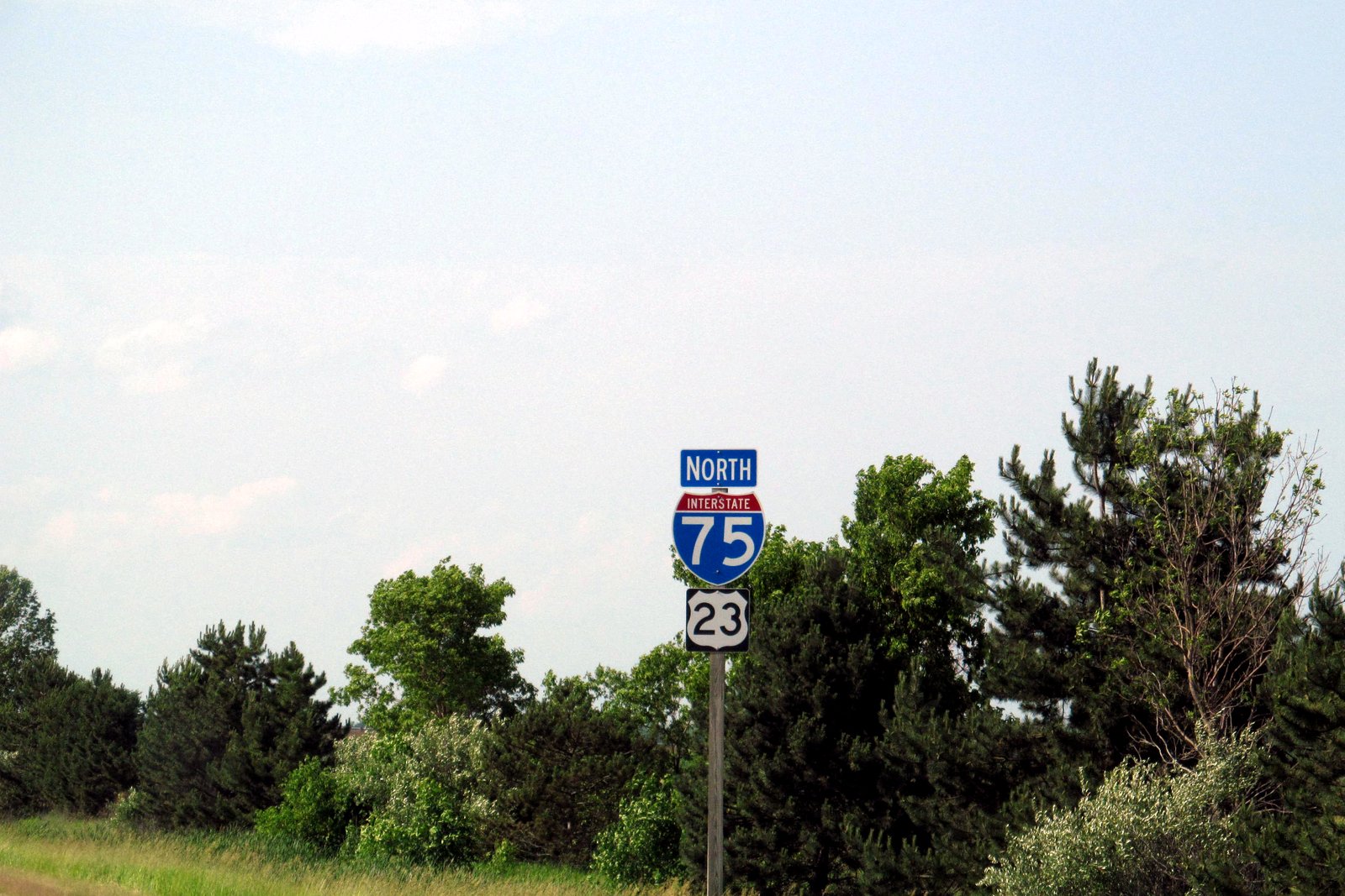 Interstate 75 and U.S. 23 north highway shields on a roadside signpost in Michigan, with trees behind them, in a file photo.