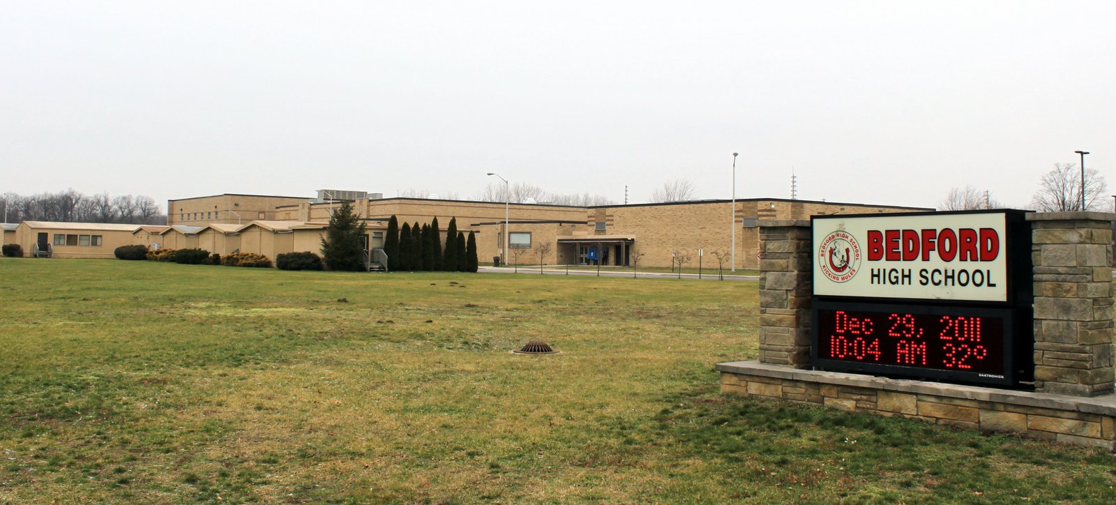 The long, low brick front of Bedford High School on Jackman Road in Temperance, with a lawn and parking lot in front.