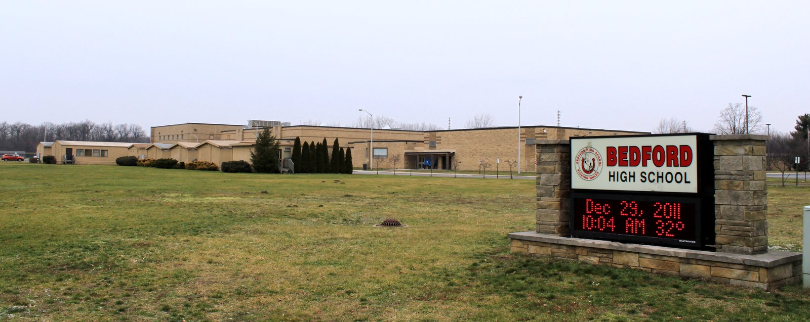 Brick facade of Bedford High School in Temperance under a clear sky.