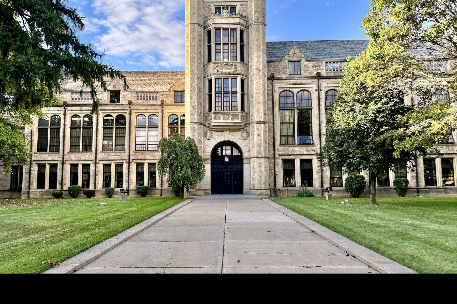 The large brick-and-stone Fordson High School building on Ford Road in Dearborn, with a central tower, many windows and a green lawn in front.