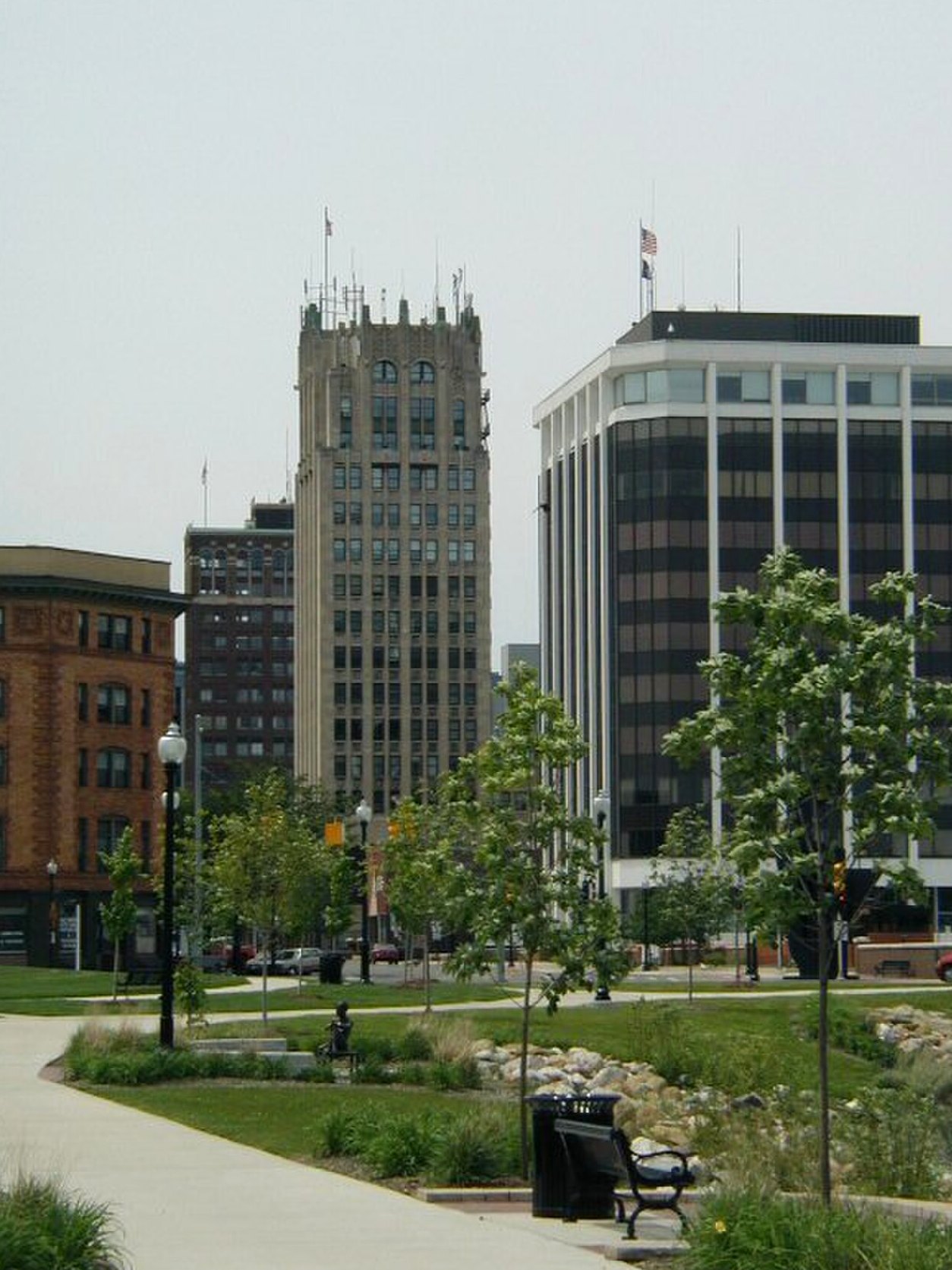 Downtown Jackson, Michigan, looking west across a lawn toward the older tower and a newer office block.