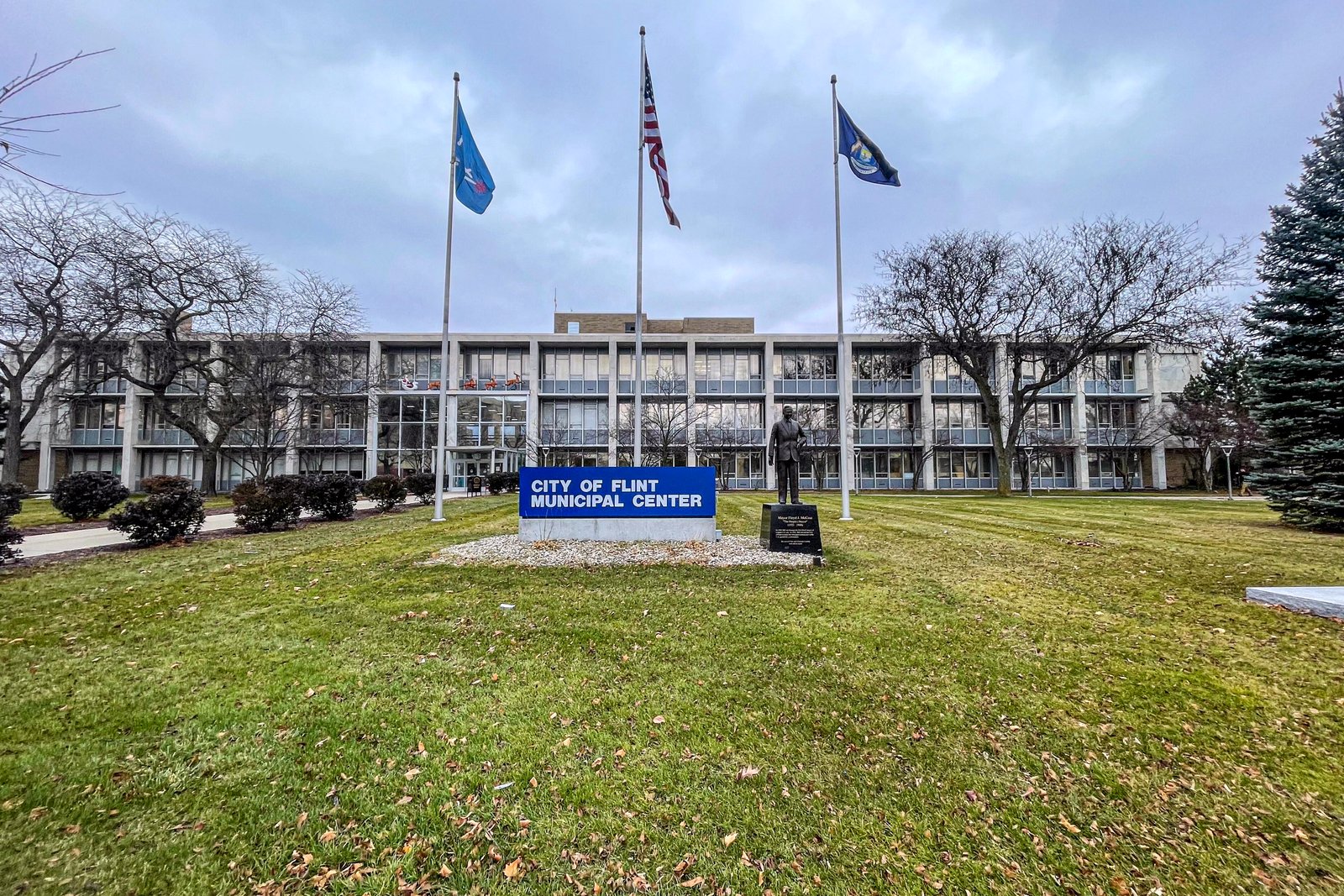 The City of Flint Municipal Center, with its sign, three flagpoles and front lawn, in a December 2023 file photo.