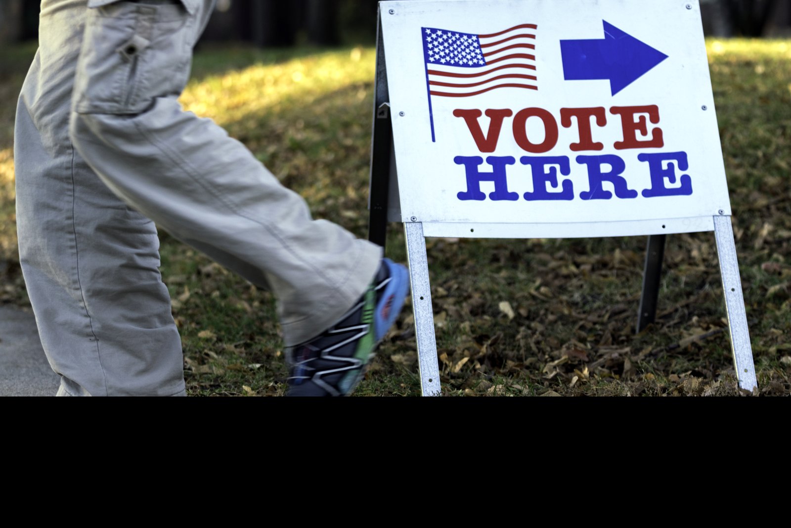 A red “Vote Here” lawn sign standing in front of a polling place, in a file photo from Minneapolis.