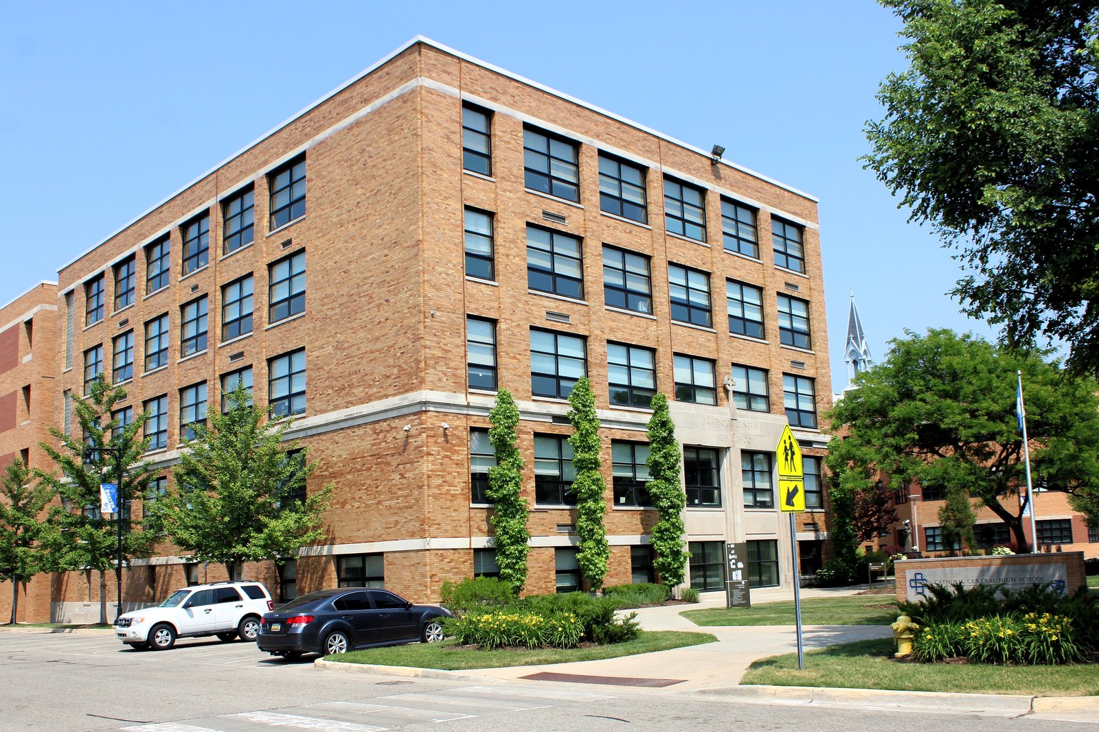 Grand Rapids Catholic Central High School, a five-story brick building with rows of windows, on a sunny day.