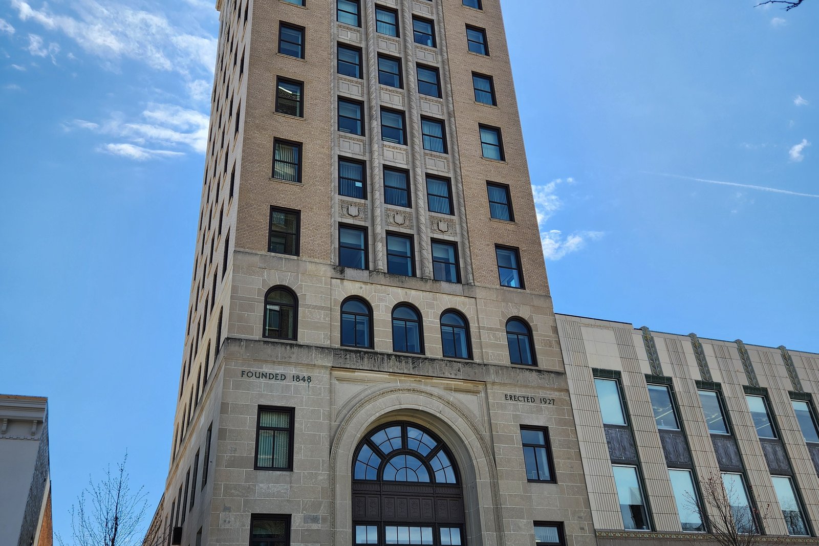 Jackson City Hall, a multi-story brick building with arched windows and a clock tower, on a sunny day downtown.