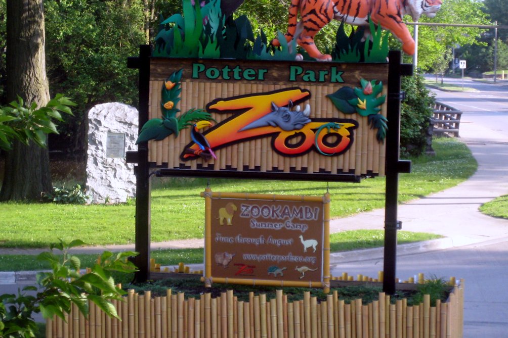 The entrance to Potter Park Zoo in Lansing, Michigan, with a stone gateway and trees along the river trail, in a file photo.