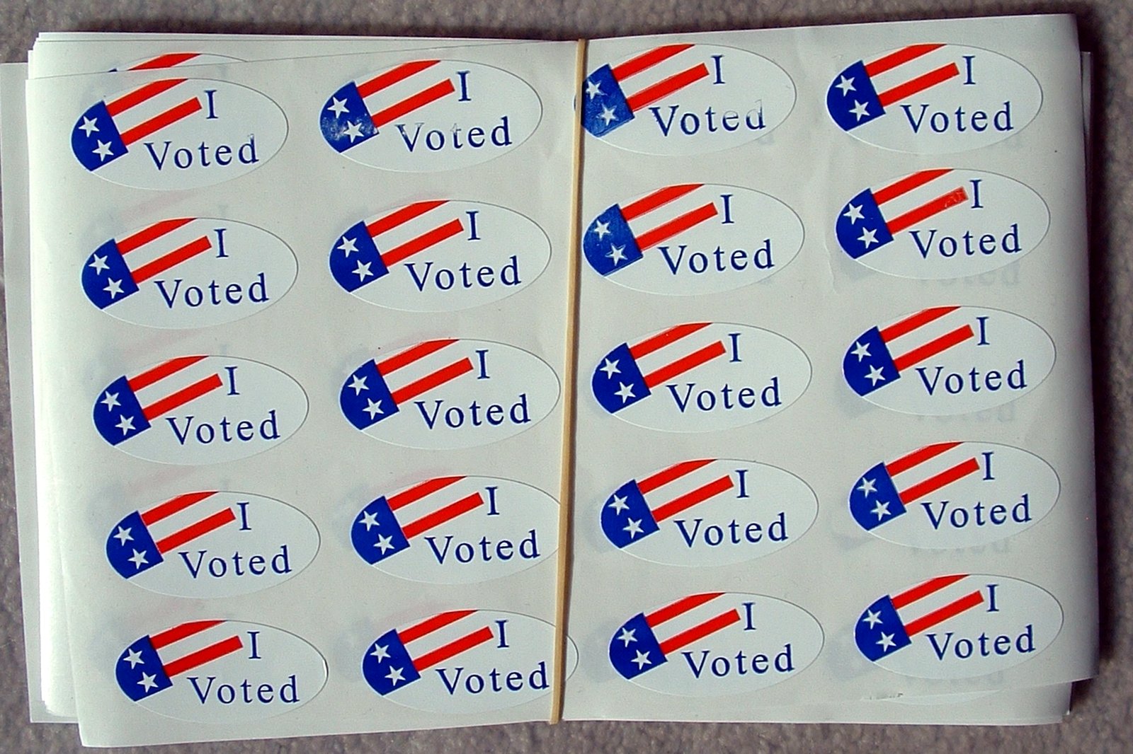 A sheet of round red, white and blue I Voted stickers with American flag designs.