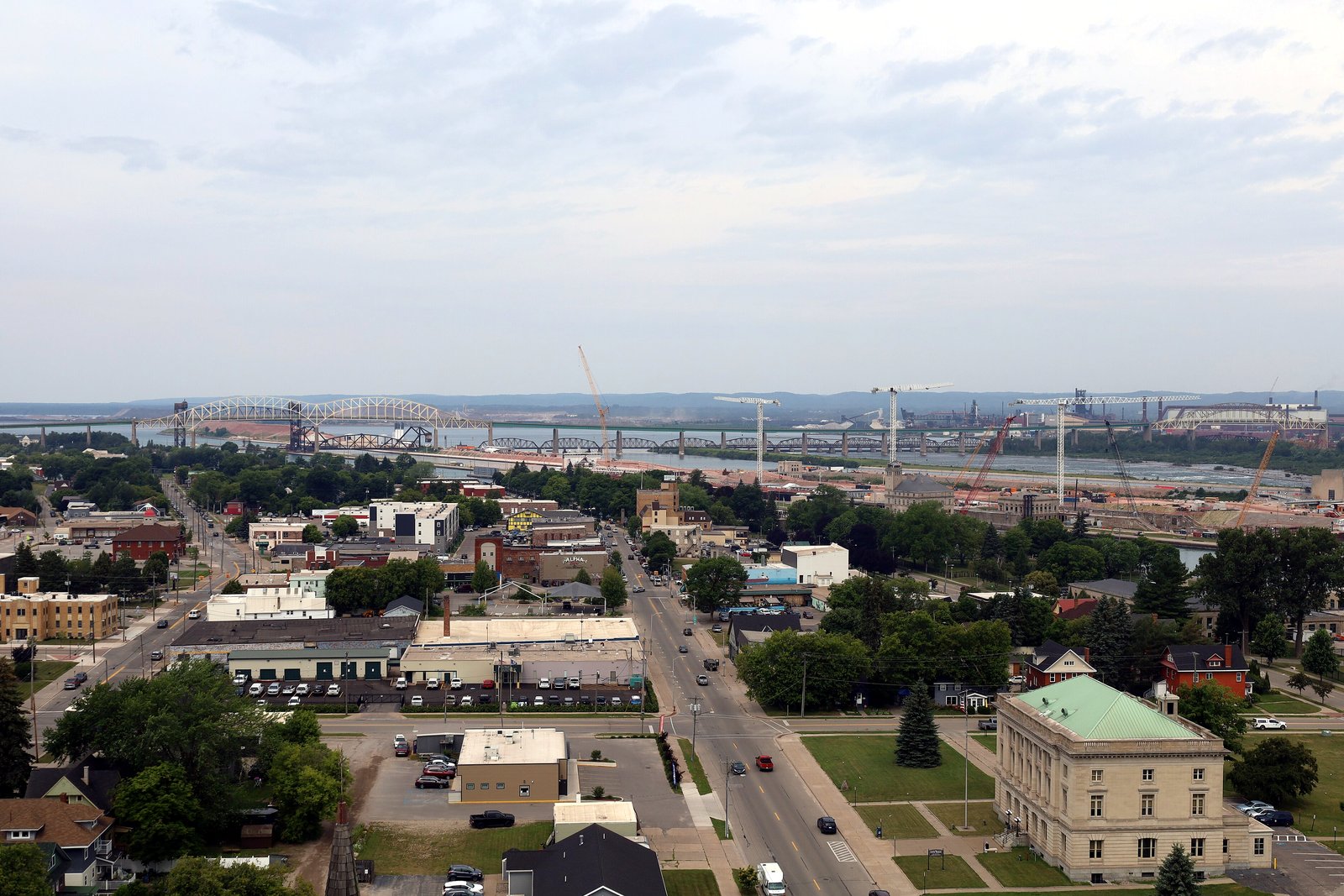 An elevated view over Sault Ste. Marie toward the Soo Locks and the St. Marys River on a clear summer day.