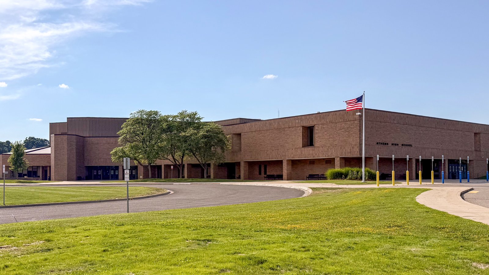 Exterior of Troy Athens High School with trees and sky.