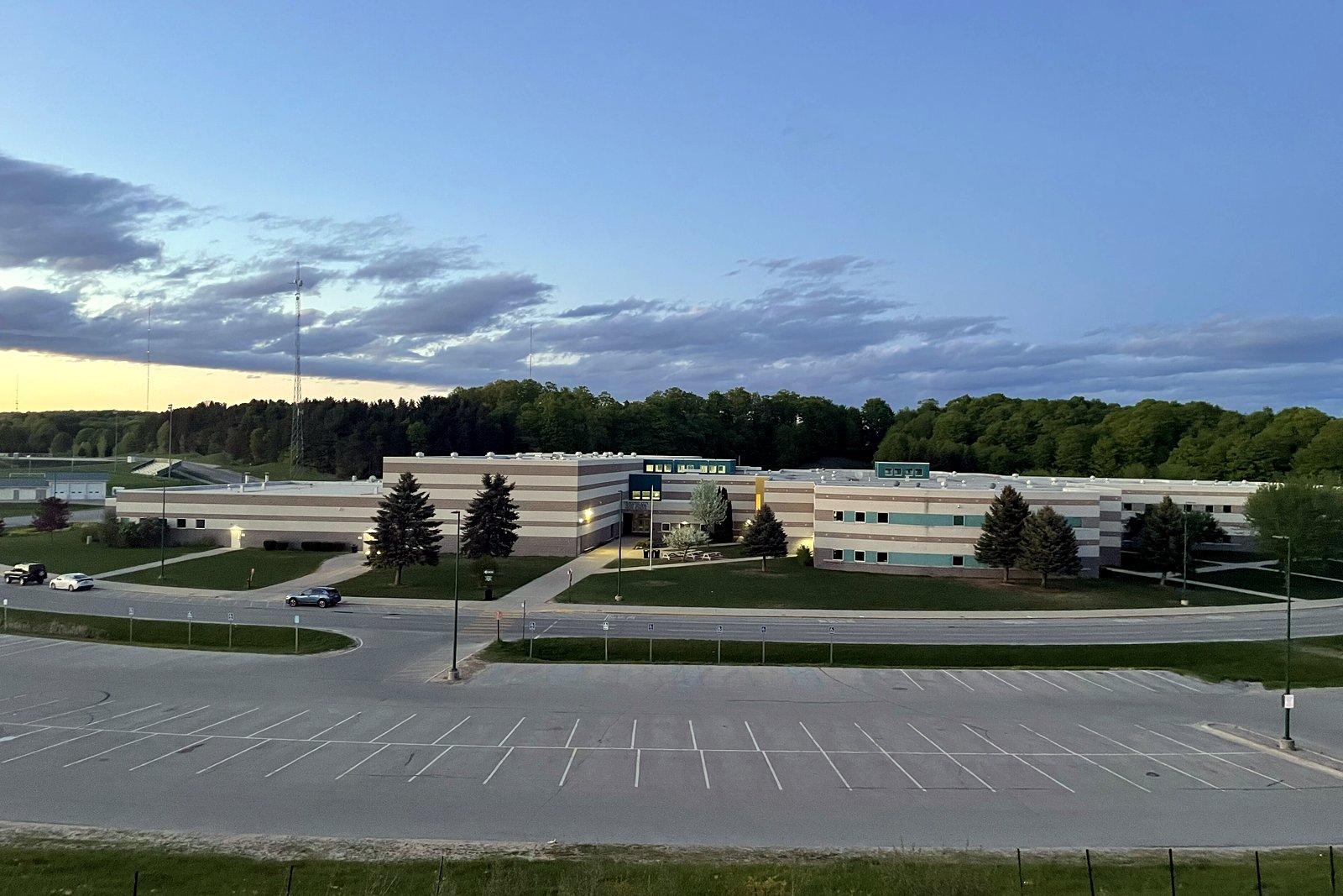 Traverse City West Senior High School seen from a distance across a wooded valley.